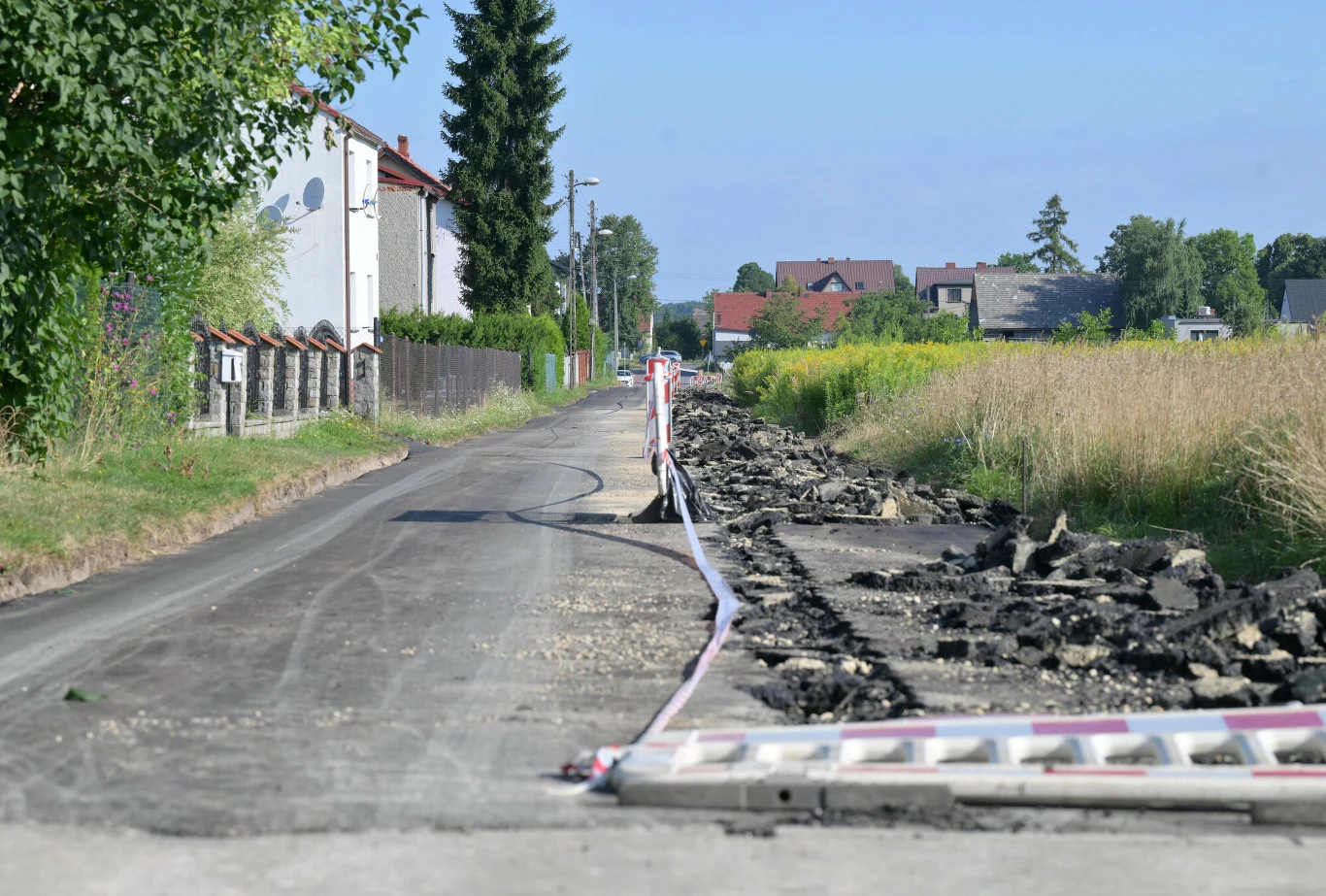 Sprawa rolnika z Gliwic. Do sądu wpłynęło zażalenie na areszt tymczasowy Zniszczony asfalt na ul. Rybackiej w Gliwicach. W tle domy i pole.