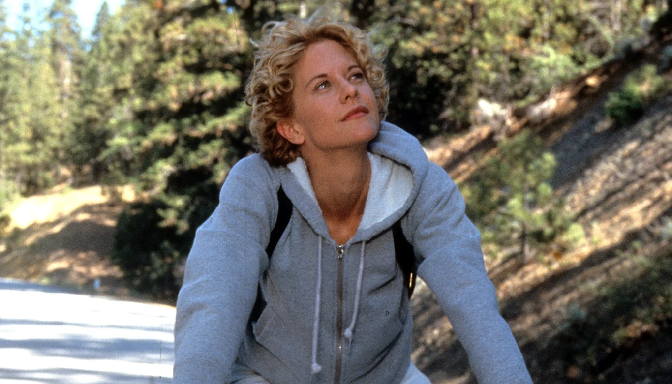 Meg Ryan w filmie "Miasto Aniołów" Meg Ryan jako Maggie Rice jedzie na rowerze leśną drogą w filmie "Miasto aniołów".