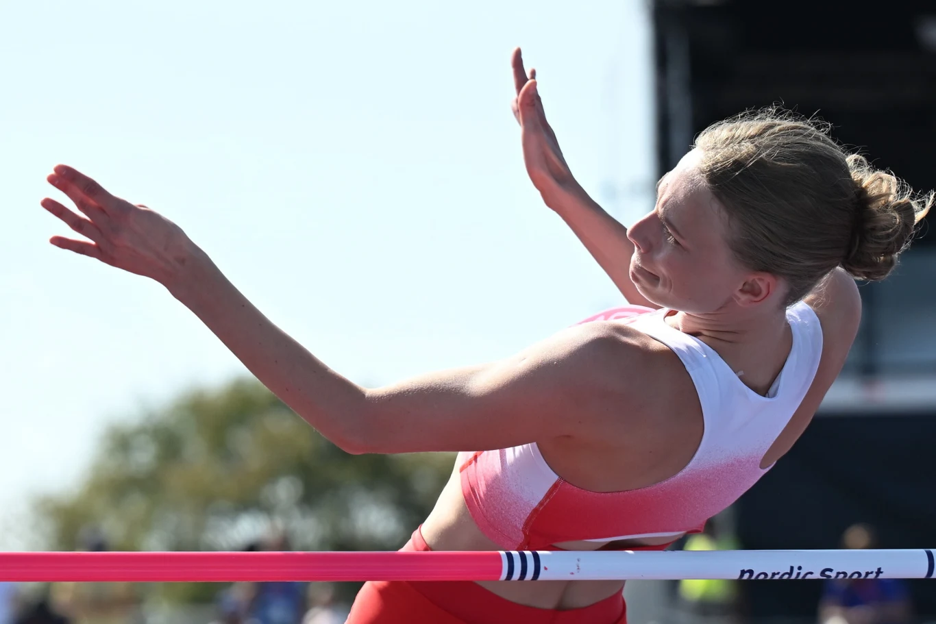 Maria Żodzik Zawodniczka w stroju sportowym przeskakująca poprzeczkę podczas konkurencji skoku wzwyż na stadionie lekkoatletycznym.