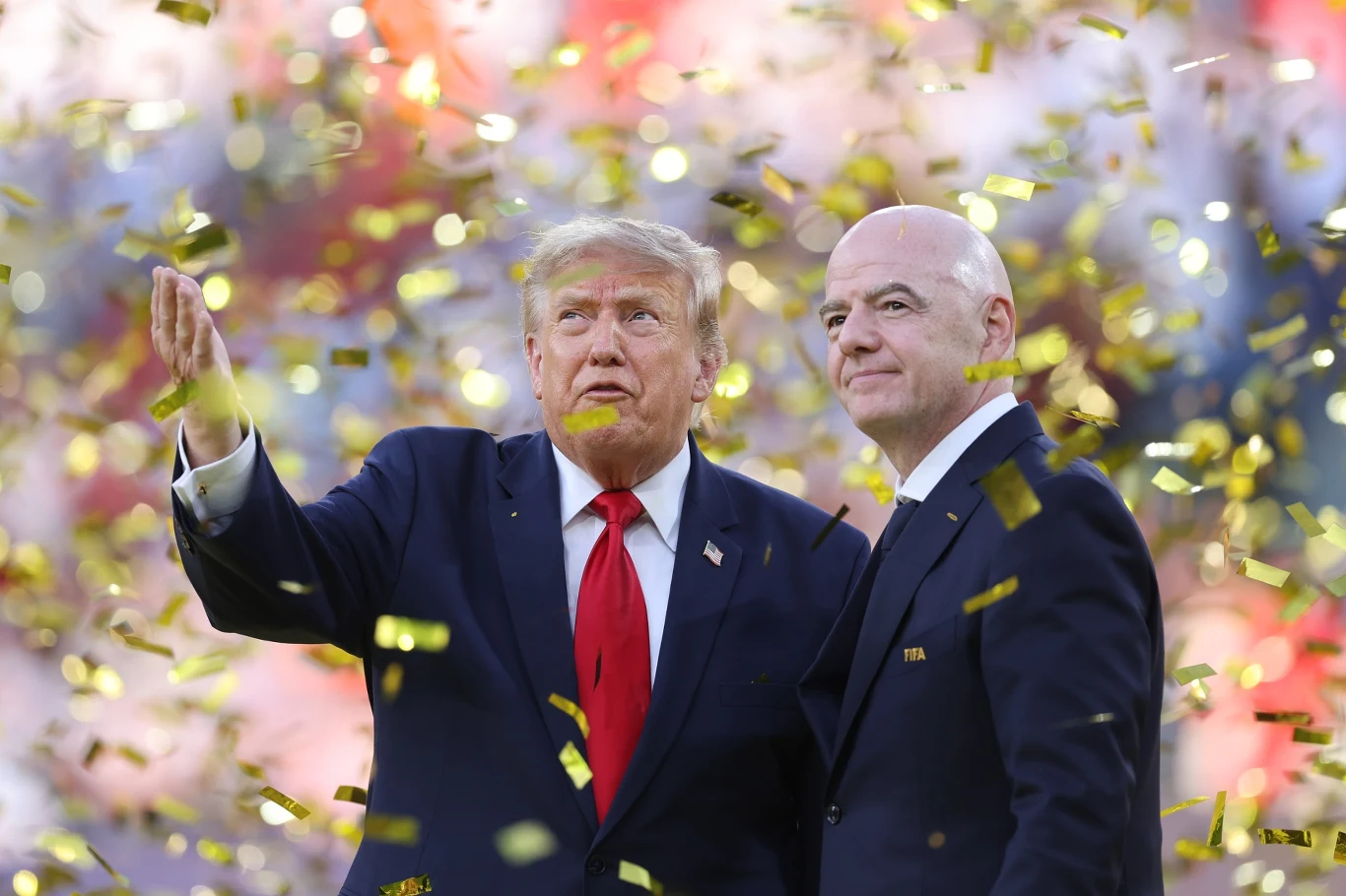 Donald Trump i Gianni Infantino Donald Trump i Gianni Infantino w garniturach stoją razem wśród złotego konfetti, jeden gestykuluje ręką.