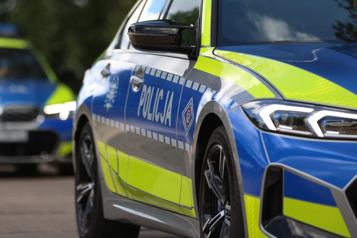 Policja otrzymała dziesiątki nowych radiowozów - 392 KM, 4,3 s do setki. Oznakowany radiowóz BMW M340i xDrive w niebiesko-żółtych barwach, z napisem 'Policja', drugi radiowóz w tle.