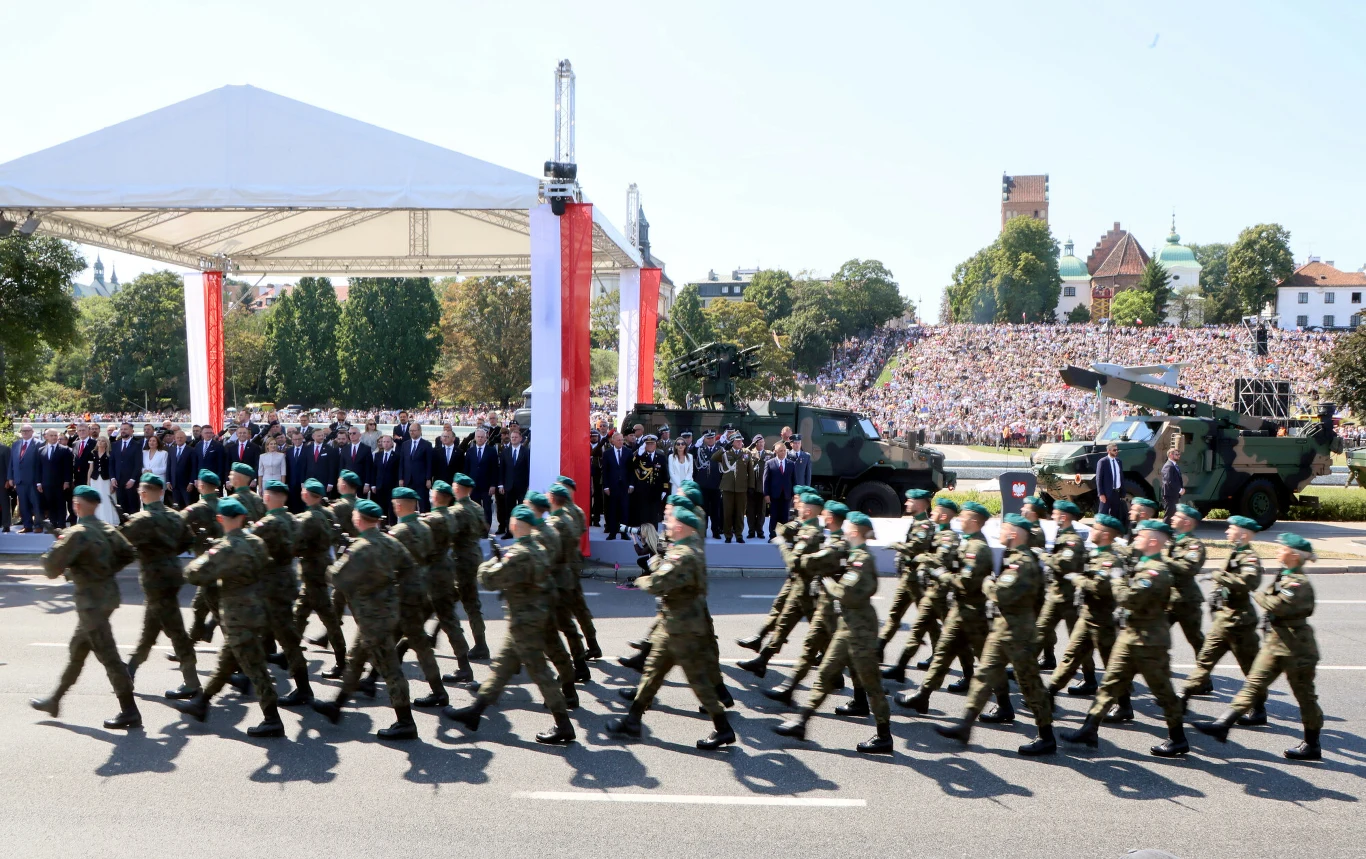 Ubiegłoroczne obchody Święta Wojska Polskiego Żołnierze maszerujący w szyku podczas obchodów Święta Wojska Polskiego, w tle sprzęt i widzowie na trybunach.