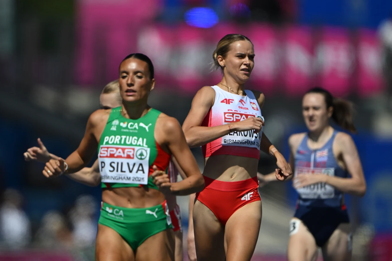 Weronika Lizakowska Zawodniczki biegnące w wyścigu lekkoatletycznym, z przodu w zielonym stroju sportsmenka reprezentująca Portugalię oraz obok niej biegaczka w biało-czerwonym stroju z Polski.