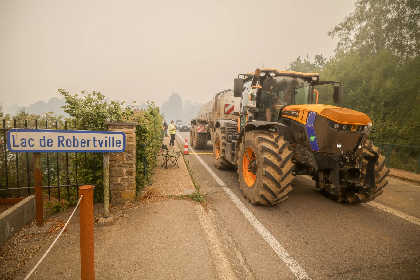 Rolnicy pobierają ciągnikami wodę z jeziora Robertville, by dostarczyć ją na miejsca objęte pożarem w Belgii.