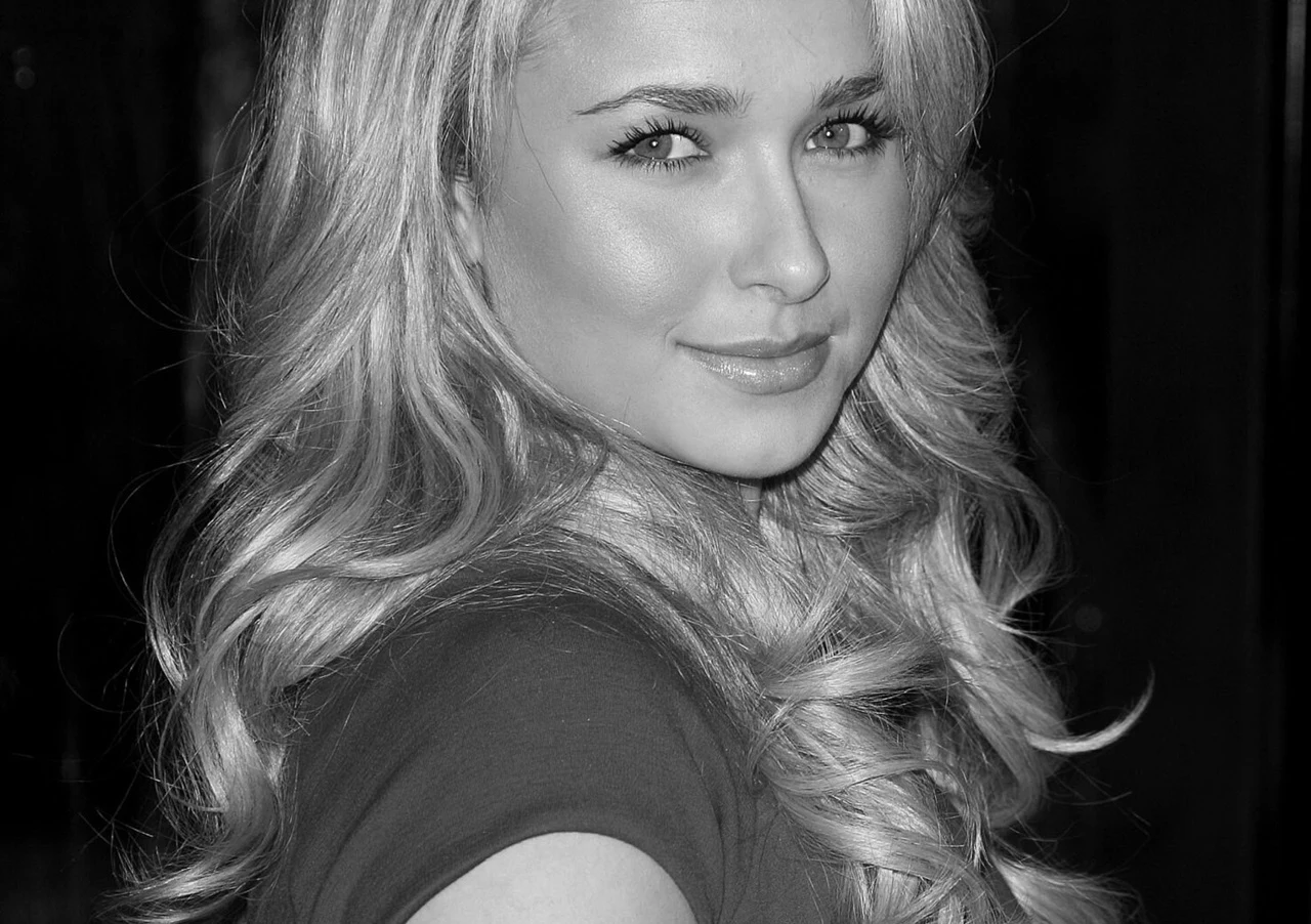 Hayden Panettiere Hayden Panettiere z długimi blond włosami, delikatnym makijażem i uśmiechem, patrząca przez ramię w obiektyw.