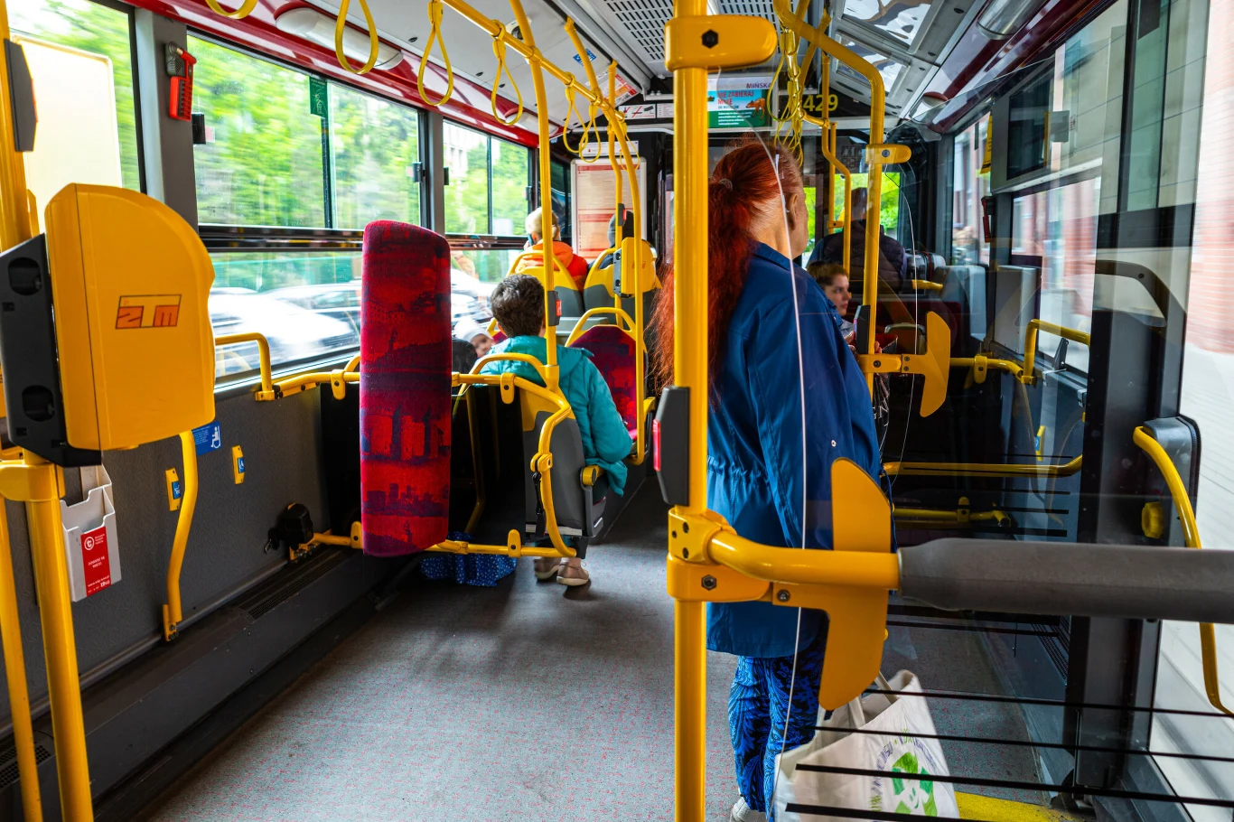 Dla Włocha szokiem okazało się to, że w przestrzeni publicznej Polacy potrafią zachowywać się naprawdę cicho Kilkoro pasażerów w miejskim autobusie, żółte poręcze, siedzenia pokryte wzorzystą tapicerką, za oknem widoczna zieleń.