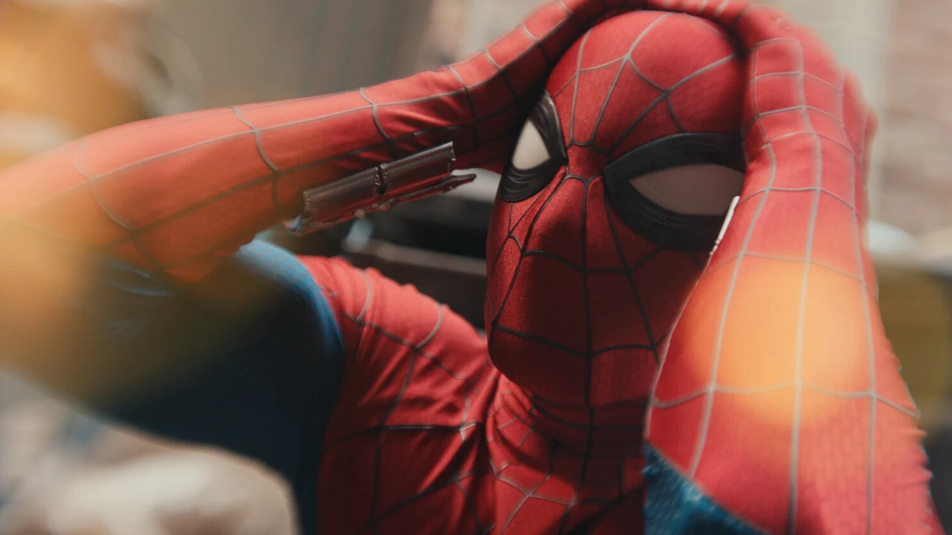 Kadr z filmu "Spider-Man: Całkiem nowy dzień" Spider-Man w czerwono-niebieskim kostiumie z dłońmi na głowie; kadr z filmu "Spider-Man: Całkiem nowy dzień".