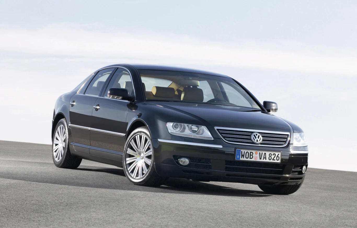 Volkswagen Phaeton był próbą wejścia marki do segmentu luksusowego Czarny sedan marki Volkswagen zbliżony z przodu, widoczny na jasnym tle, z charakterystycznym chromowanym grillem i dużymi aluminiowymi felgami.