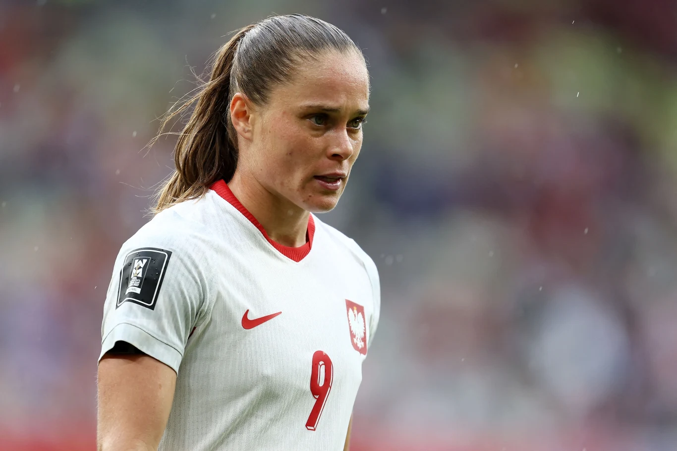 EA Sports FC 27: Ewa Pajor lepsza od Roberta Lewandowskiego Piłkarka w białym stroju z czerwonym numerem 9 oraz godłem Polski na piersi podczas meczu na stadionie.