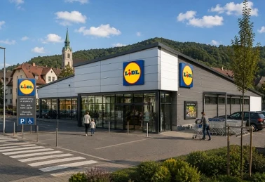 Sklep Lidl z zewnątrz — wejście, parking i pylon z godzinami otwarcia 