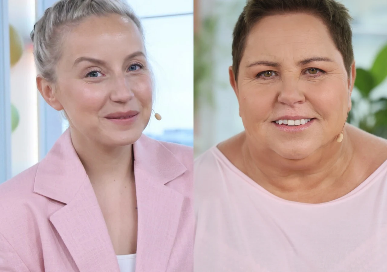Sandra Hajduk-Popińska, Dorota Wellman Dwie uśmiechnięte kobiety ubrane w jasnoróżowe stroje, każda ma przypięty mikrofon i stoi w dobrze oświetlonym pomieszczeniu.