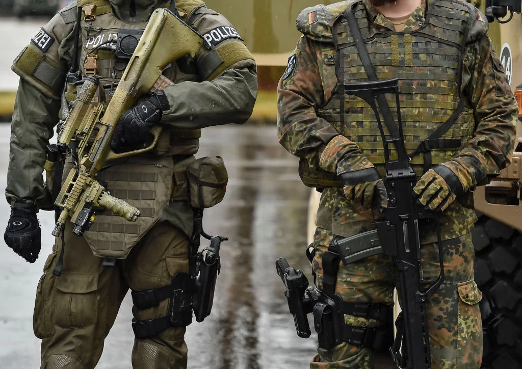 Siły specjalne niemieckiej policji. Zdj. ilustracyjne Dwóch uzbrojonych funkcjonariuszy niemieckiej policji w kamizelkach kuloodpornych i mundurach z karabinami.