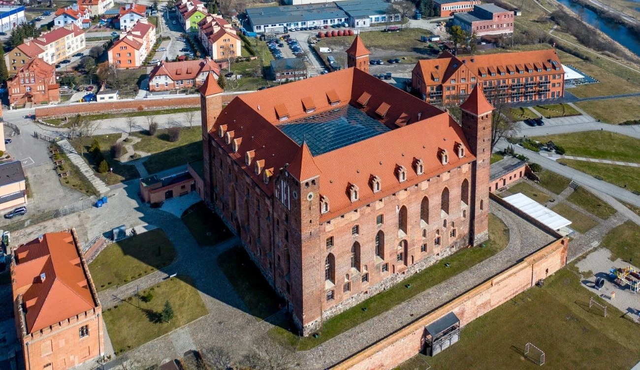 Zamek krzyżacki w Gniewie to znakomity pomysł na krótką wycieczkę Ceglany zamek krzyżacki w Gniewie z czterema narożnymi wieżami, dużym dziedzińcem i czerwoną dachówką.