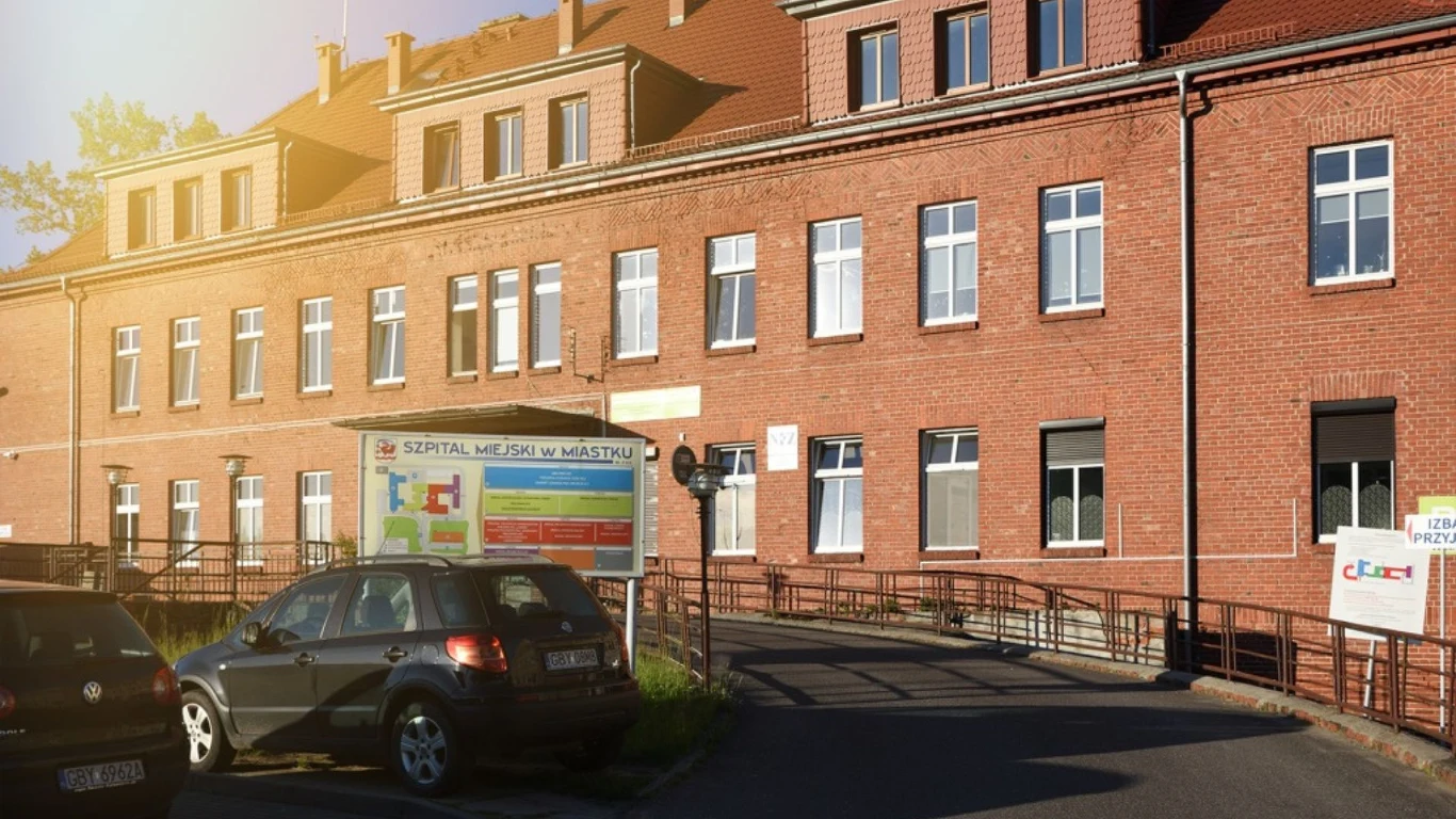 Szpital w Miastku. Placówka ogłasza upadłość Ceglany budynek Szpitala Miejskiego w Miastku z oknami, podjazdem i tablicą informacyjną przy parkingu.
