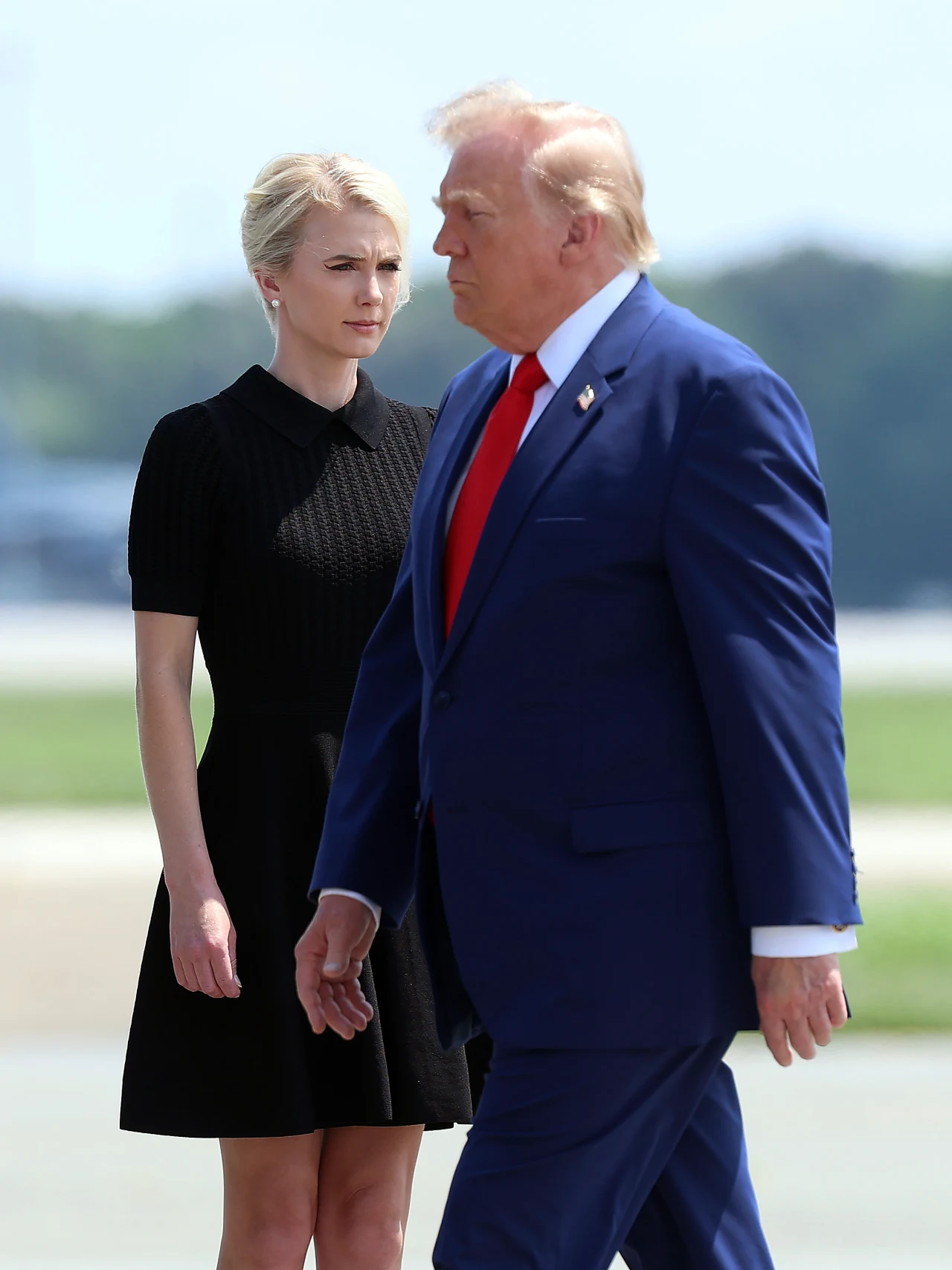 Postać Natalie Harp wywołuje obecnie wielkie kontrowersje w amerykańskich mediach Mężczyzna w niebieskim garniturze z czerwonym krawatem idzie obok kobiety w czarnej, krótkiej sukience na tle otwartej przestrzeni.