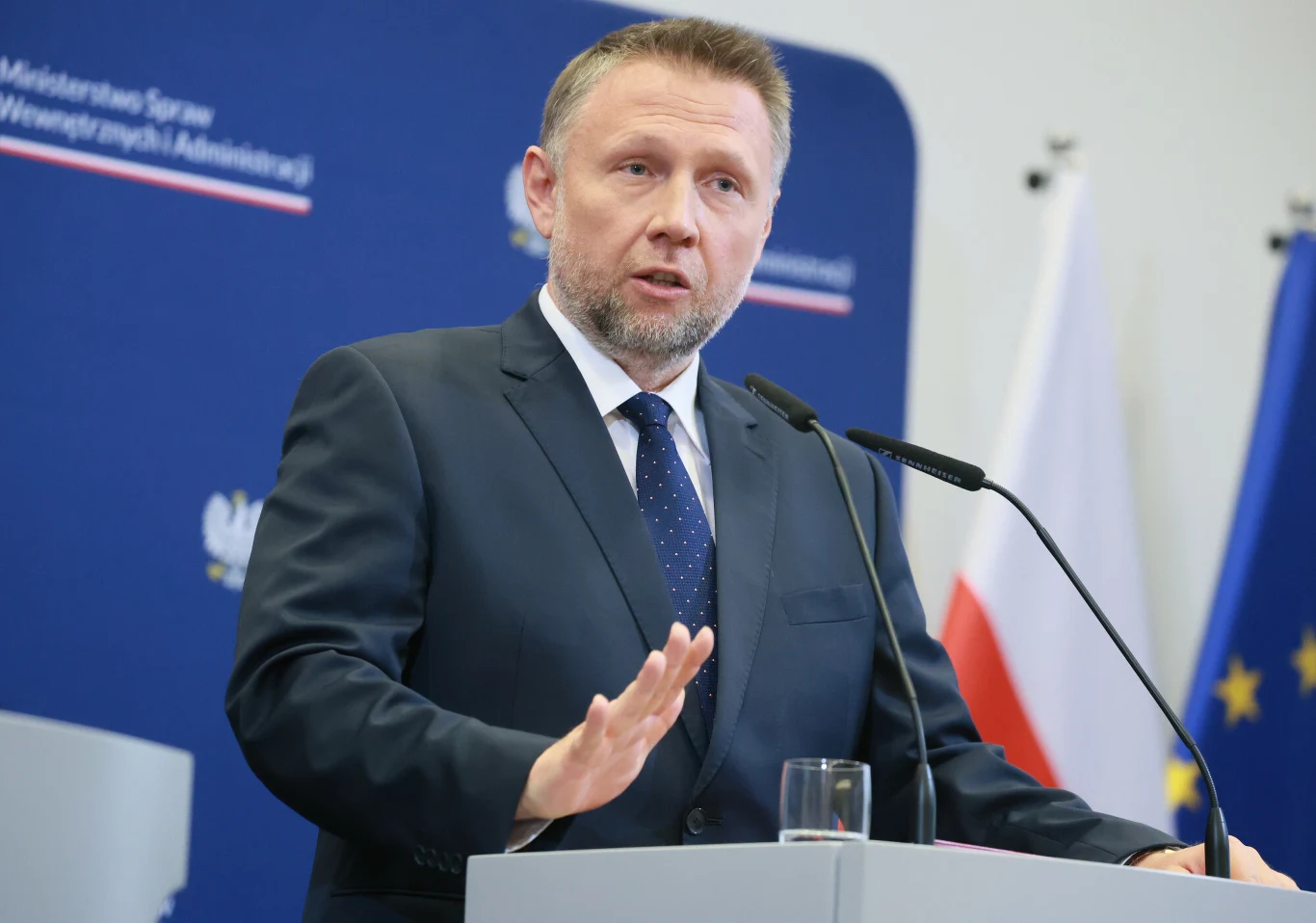 Szef MSWiA Marcin Kierwiński Marcin Kierwiński, szef MSWiA, przemawia przy mównicy, w tle flagi Polski i UE oraz tablica ministerstwa