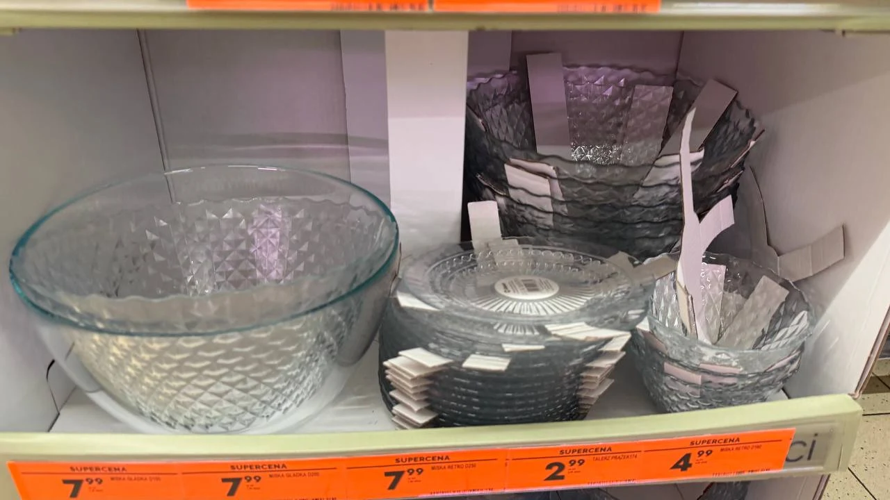 Szklane miski i talerzyki o różnych rozmiarach i fakturze ustawione na półce sklepowej, każda z nich posiada naklejki z ceną i etykiety produktowe.