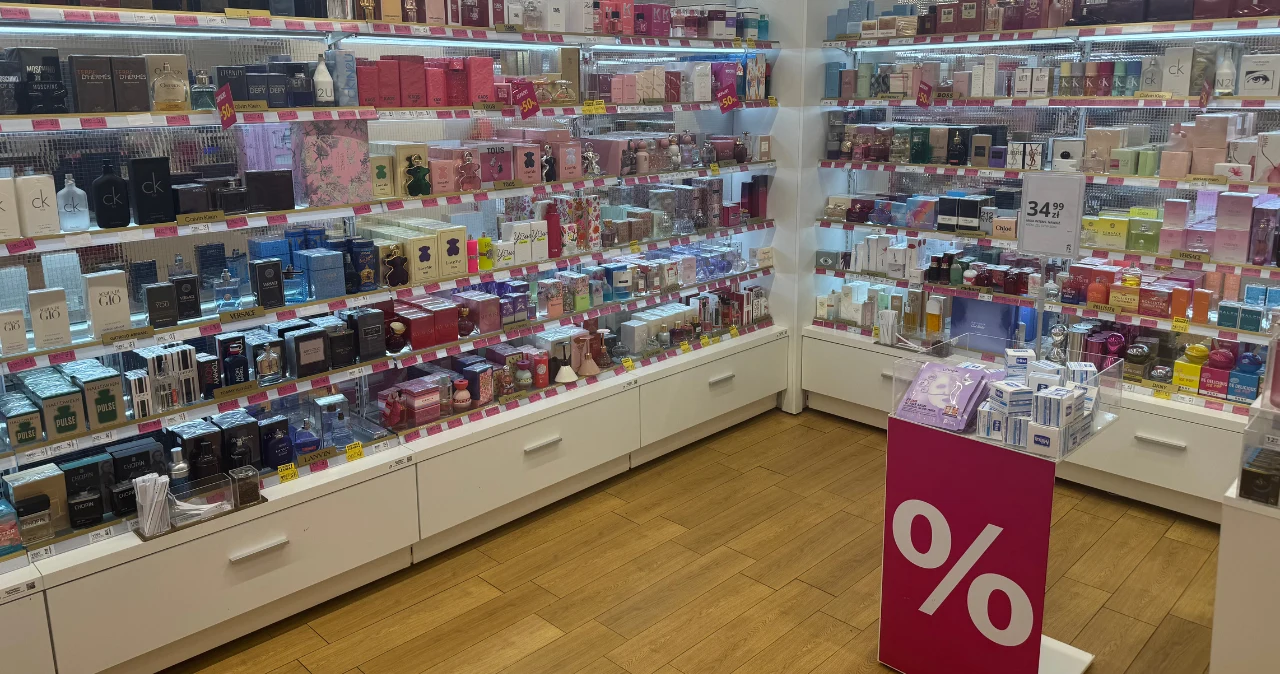 Hebe mocno przeceniło markowe perfumy. Na jednym flakonie można zaoszczędzić aż 150 zł Półki z flakonami perfum w Hebe, na środku promocja na markowe zapachy, stojak z symbolem procenta.
