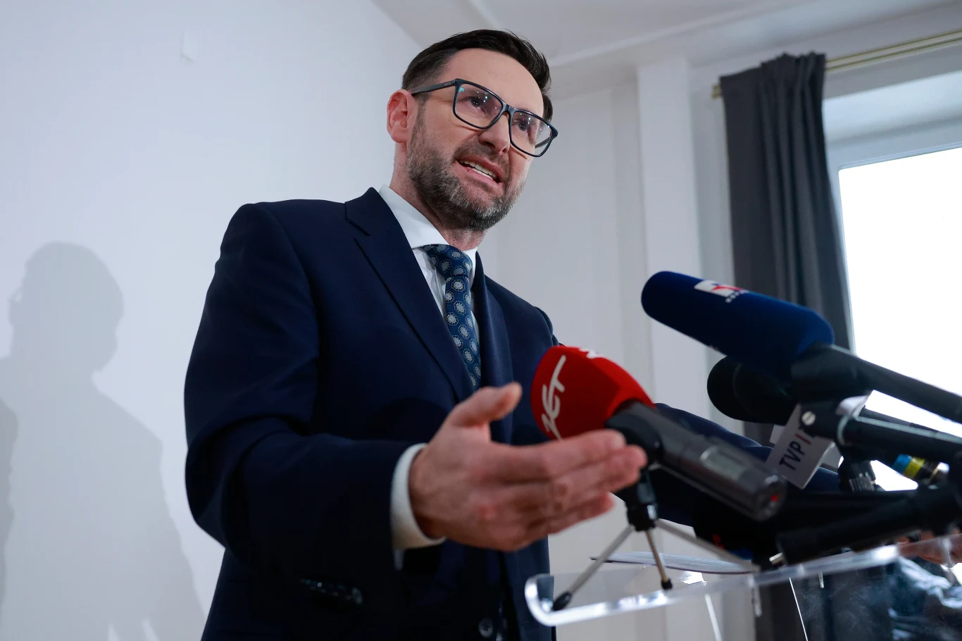 Bydgoska prokuratura wszczęła śledztwo w sprawie Daniela Obajtka Daniel Obajtek w garniturze i okularach przemawia do mikrofonów na konferencji prasowej, gestykulując dłonią.