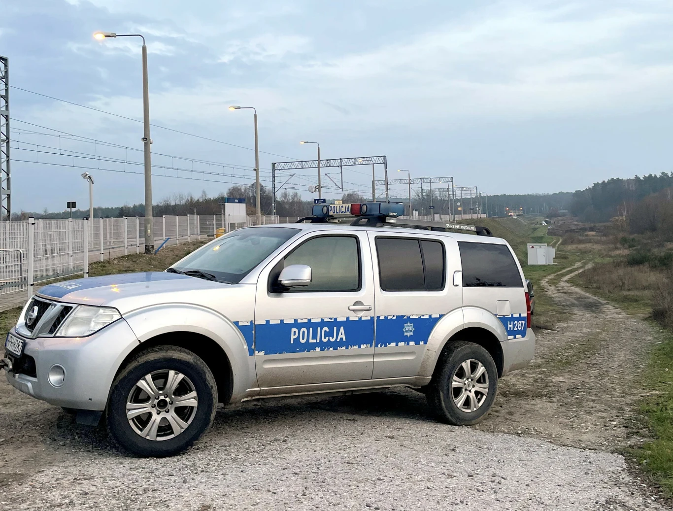 Policja bada incydent na torach na Lubelszczyźnie (zdj. ilustr.) Na pierwszym planie samochód policyjny, w tle torowisko
