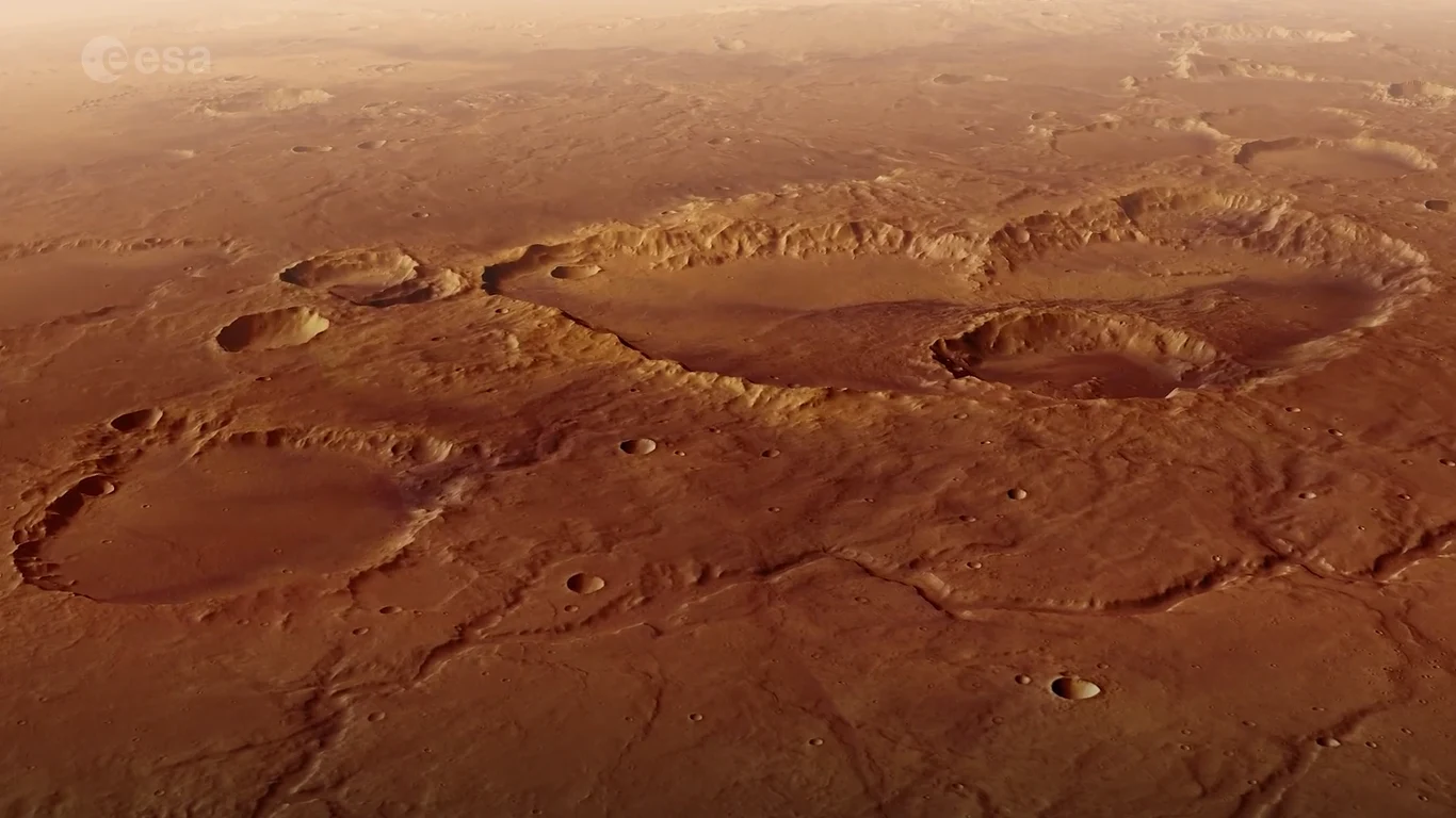 Niesamowite nagranie z sondy Mars Express. Tutaj utknął "Marsjanin". Widok na powierzchnię Marsa z rozległym kraterem Schiaparelli i licznymi mniejszymi kraterami wokół.
