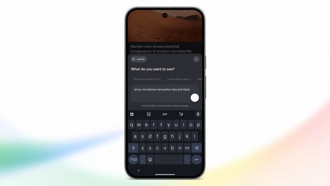 Google Discover pozwoli spersonalizować tablicę własnymi słowami Smartfon z aktywną funkcją wyszukiwania tekstowego oraz widoczną klawiaturą ekranową, na ekranie tekstowe polecenia i odpowiedzi, tło rozmyte w jasnych kolorach.