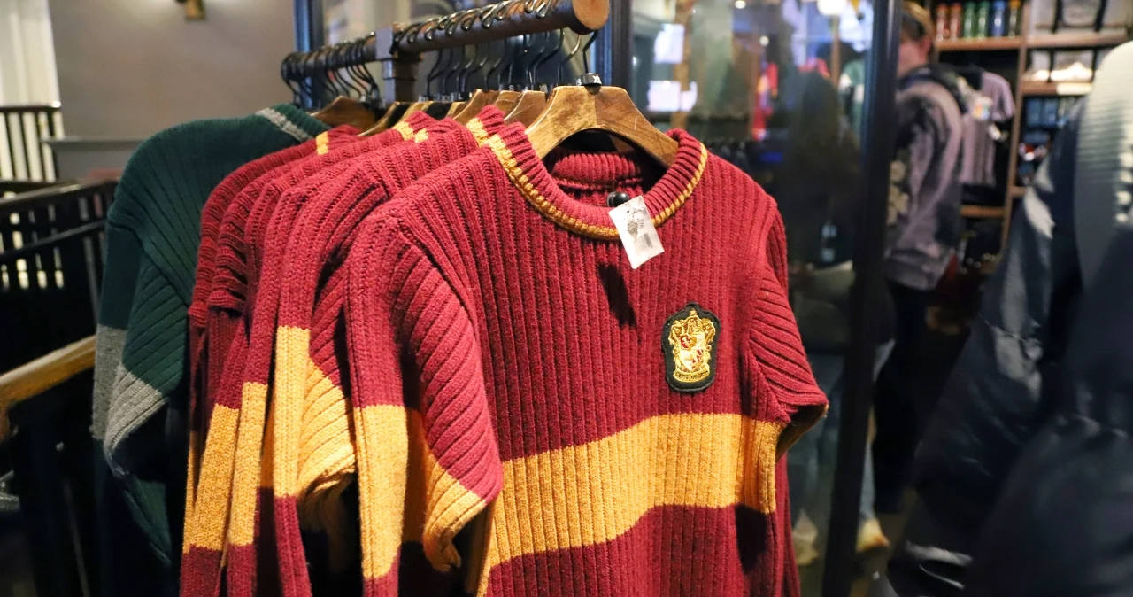 25 lat Harry’ego Pottera. Smyk ruszył z kolekcją dla młodych fanów od 29,99 zł Czerwono-żółte swetry z herbem Gryffindoru na drewnianych wieszakach w sklepie Smyk.