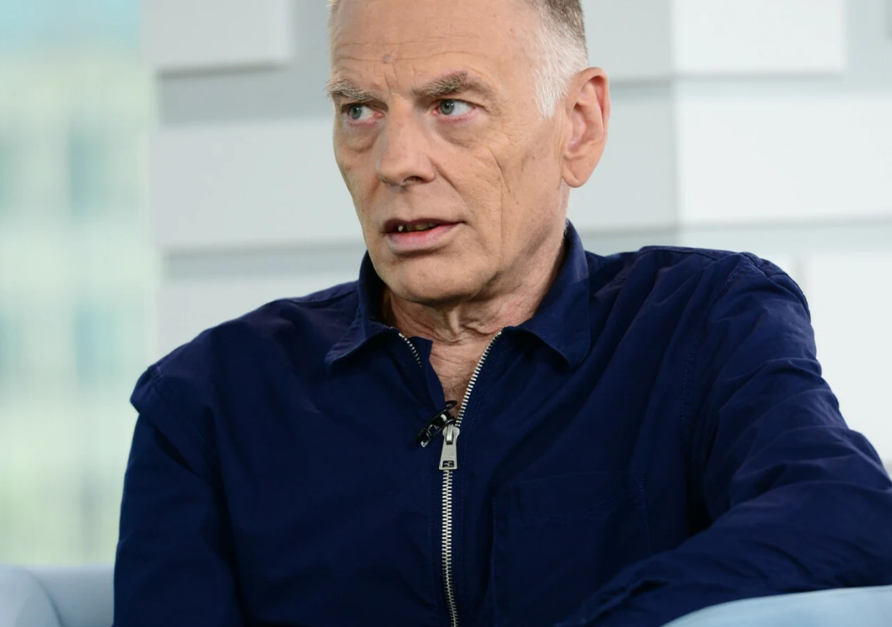 Tomasz Lipiński Tomasz Lipiński w nowoczesnym wnętrzu, ubrany w granatową koszulę, zdjęcie portretowe.