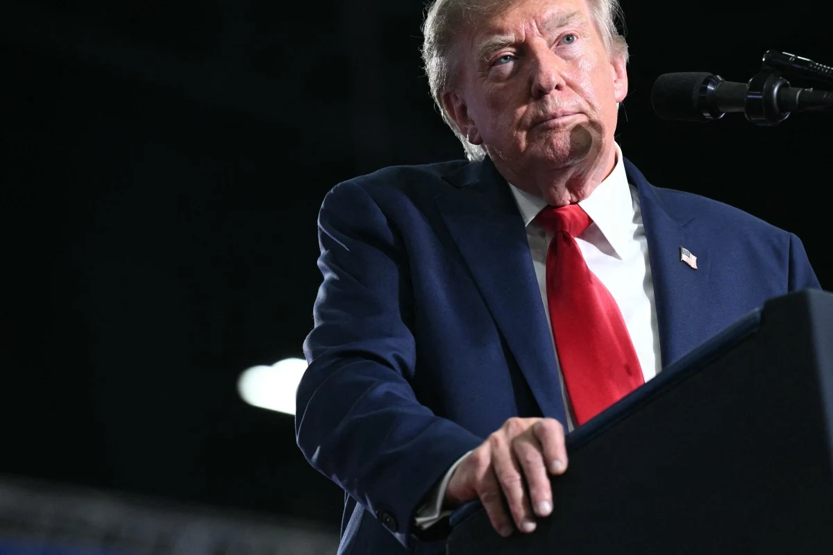 Prezydent USA Donald Trump podczas wiecu wyborczego na rzecz Darline Graham Donald Trump stoi przy mównicy w garniturze i czerwonym krawacie podczas wiecu na rzecz Darline Graham.