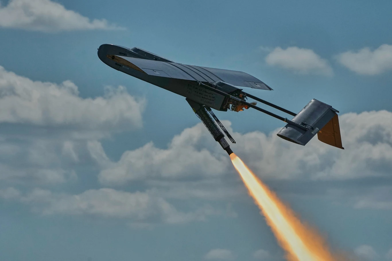 Ukraiński dron FP-1 Bezzałogowy dron wojskowy w trakcie startu z użyciem napędu rakietowego na tle nieba z chmurami.