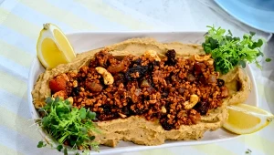 Ragù z kurczaka w sosie pomidorowym z rodzynkami i orzechami, na purée z ciecierzycy i karmelizowanej cebuli