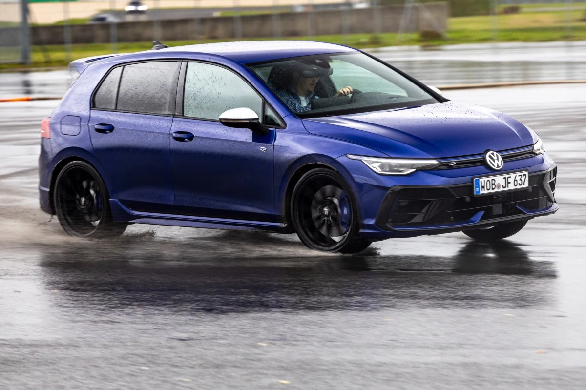 Volkswagen Golf R to jeden z najsprawniejszych hothatchy w swojej klasie. /zdj. ilustracyjne Niebieski Volkswagen Golf R porusza się dynamicznie po mokrej nawierzchni, z przednimi kołami skierowanymi pod dużym kątem, co wskazuje na jazdę w poślizgu wodnym lub kontrolowany drift; w samochodzie widoczny kierowca skoncentrowany na torze jazdy.