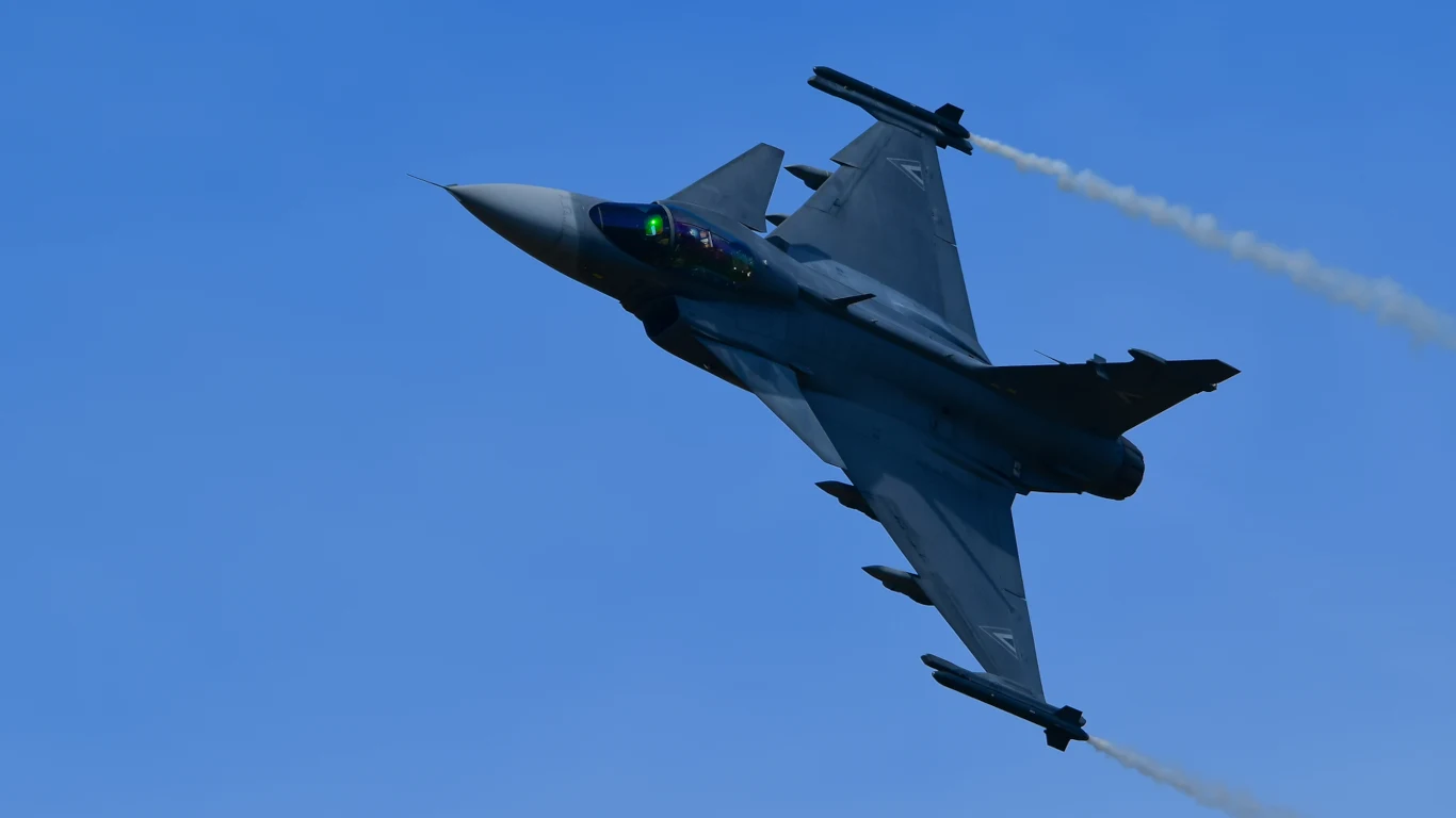 Katastrofa na Węgrzech. Rozbił się myśliwiec, pilot przeżył. Węgierski myśliwiec JAS-39C Gripen z pochylonymi skrzydłami lecący na tle nieba