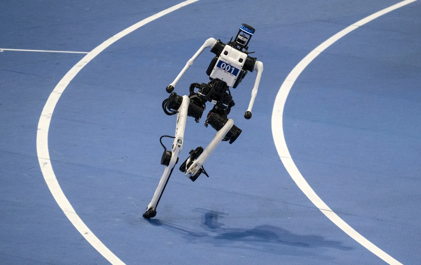 Roboty pobiły rekord Usaina Bolta w biegu na 100 metrów w Pekinie Dwunożny robot z numerem 001 biegnący po niebieskiej bieżni podczas zawodów w Pekinie.