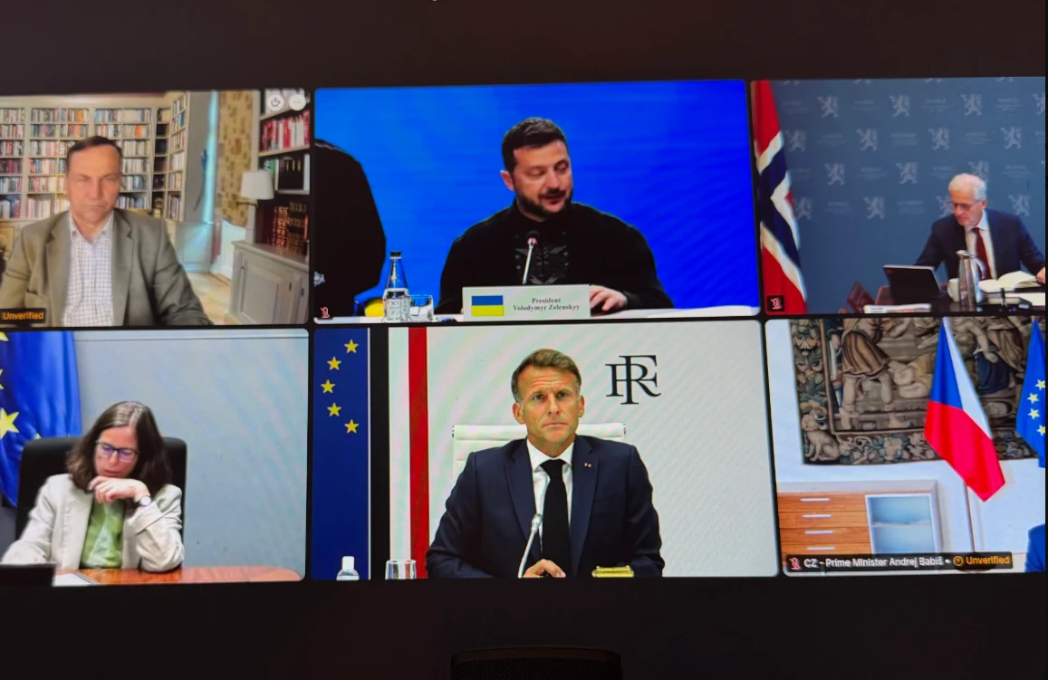 Wideokonferencja z udziałem sześciu osób, w tym prezydenta Ukrainy Wołodymyra Zełenskiego, premiera Norwegii oraz innych liderów politycznych, każdy w oddzielnym kadrze, z wyraźnie widocznymi flagami państwowymi i symbolami Unii Europejskiej w tle.