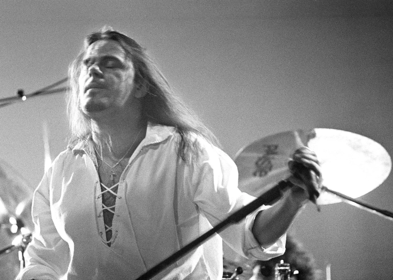 Doogie White na trasie z Rainbow - Rotterdam (Holandia), 17 października 1995 r. Doogie White w białej koszuli z mikrofonem na scenie, Rotterdam, 1995; w tle część perkusji.