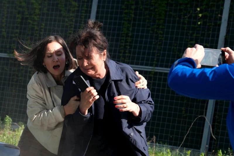 Agnes (Amanda Mincewicz) i Maria (Małgorzata Pieńkowska) zostaną poszkodowane w groźnym wypadku Agnes obejmuje Marię po wypadku; obok mężczyzna fotografuje scenę smartfonem.