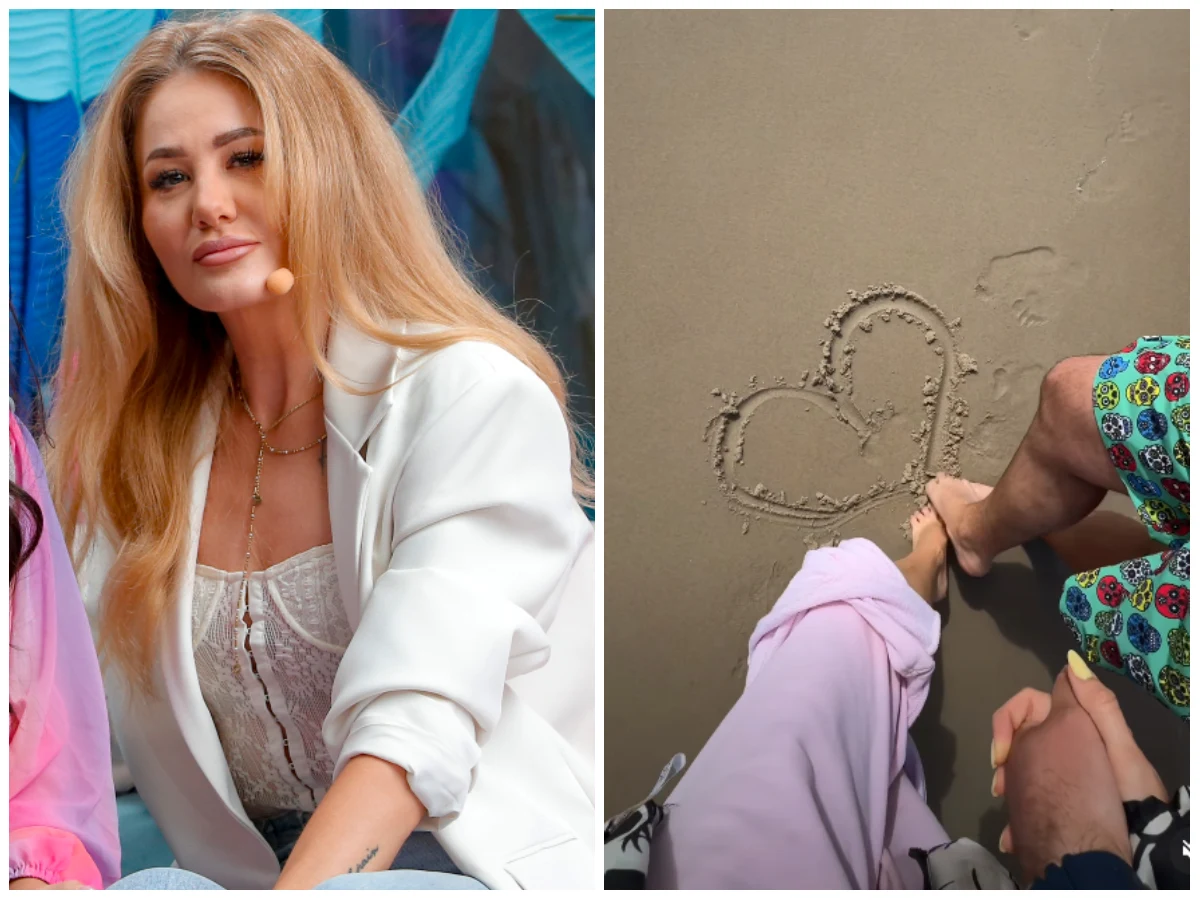 Kobieta z długimi blond włosami w białej marynarce siedzi w studio, obok zdjęcie dwóch osób w kolorowych ubraniach stojących bosymi stopami na piasku, na którym narysowane jest serce.