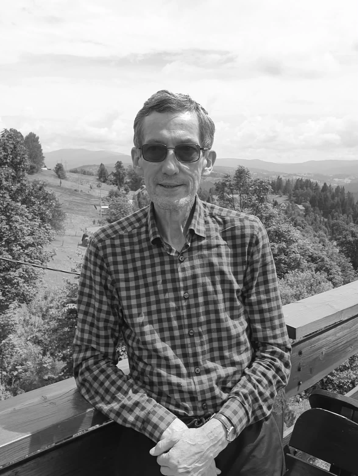 Nie żyje Czesław Śleziak. Miał 74 lata Mężczyzna w okularach przeciwsłonecznych i koszuli w kratę siedzi na ławce z widokiem na zalesione pagórki i góry w tle.