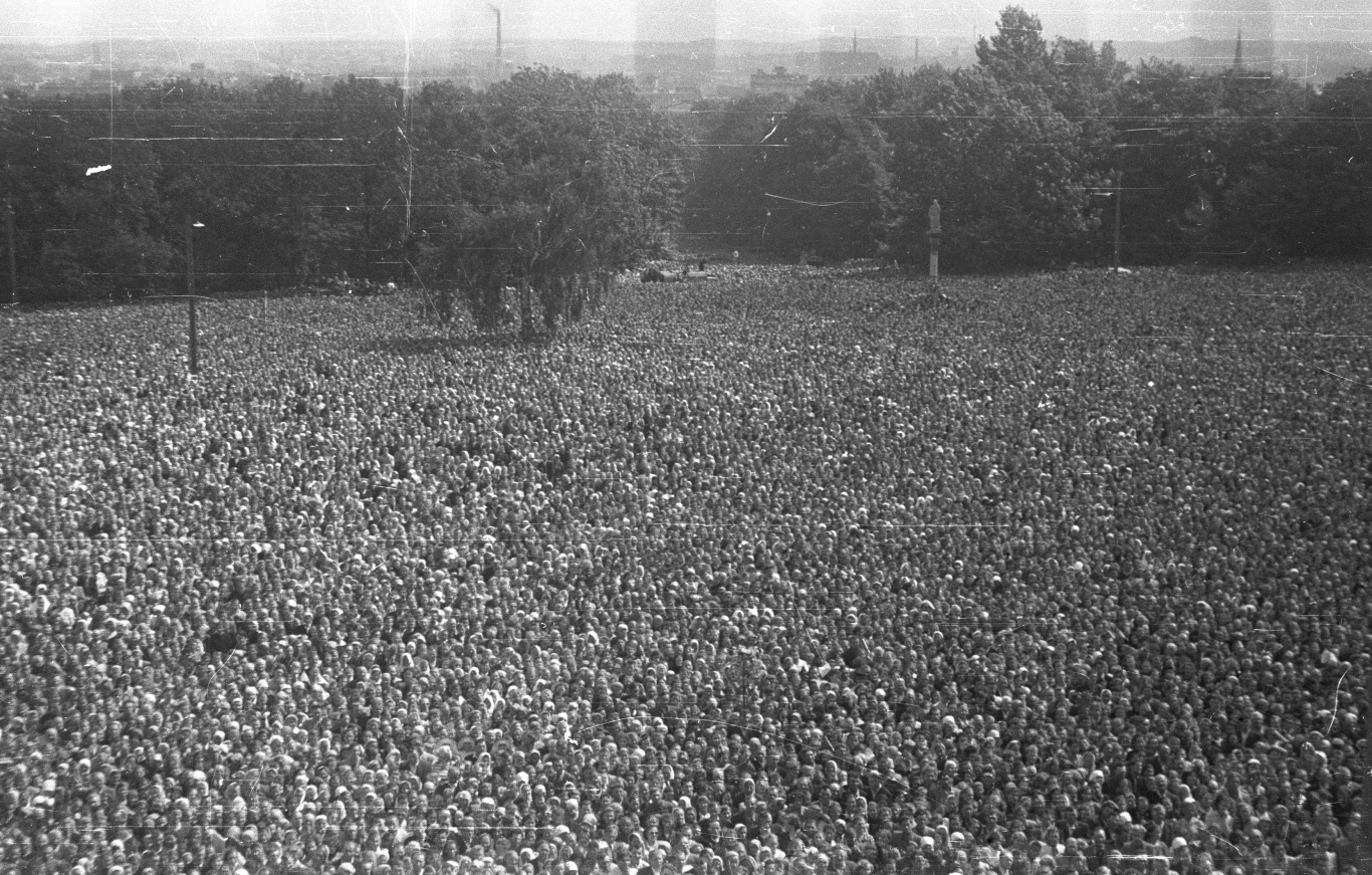 Na Jasną Górę w 1956 roku przybyło ok. 700 - 800 tysięcy wiernych Tłum ludzi zgromadzonych na otwartej przestrzeni, w tle drzewa i pojedyncze wysokie słupy, na horyzoncie ledwo widoczne zarysy budynków.