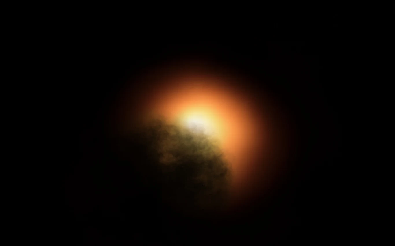 Betelgeza na nowym zdjęciu. Gwiazda uchwycona jak nigdy wcześniej. Betelgeza z jasną pomarańczową poświatą wokół ciemnej bryły na czarnym tle, zdjęcie z ALMA