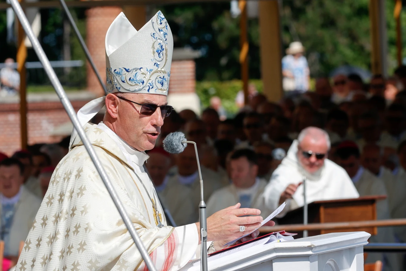 Prymas abp. Wojciech Polak podczas mszy na Jasnej Górze Abp Wojciech Polak w mitrze i okularach przemawia podczas mszy na Jasnej Górze, obok inni duchowni w białych szatach.