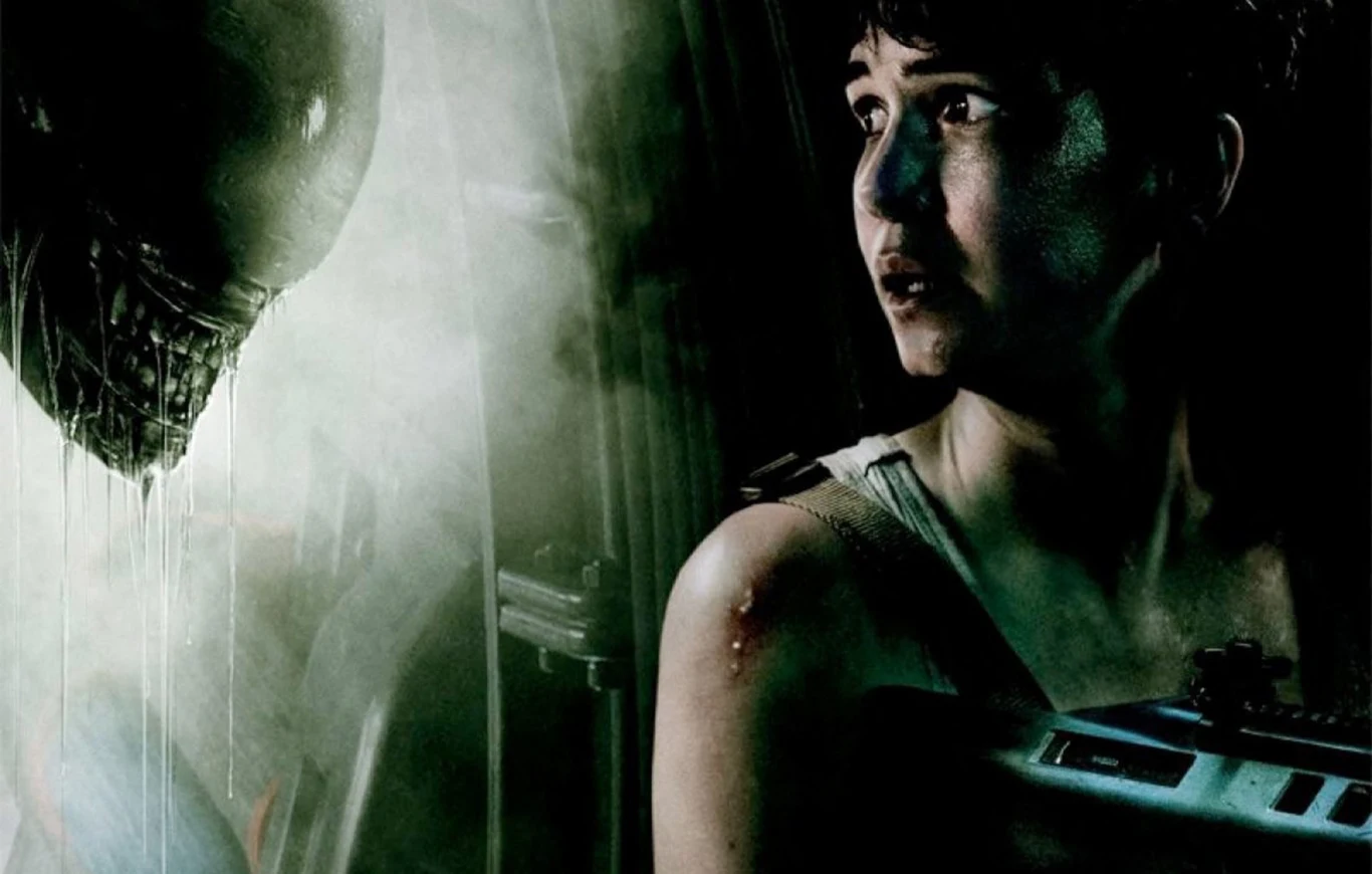 "Alien: Covenant" - fragment filmowego plakatu Plakat filmu 'Alien: Covenant' z kobietą z bronią naprzeciw kosmicznego potwora o ostrych zębach.