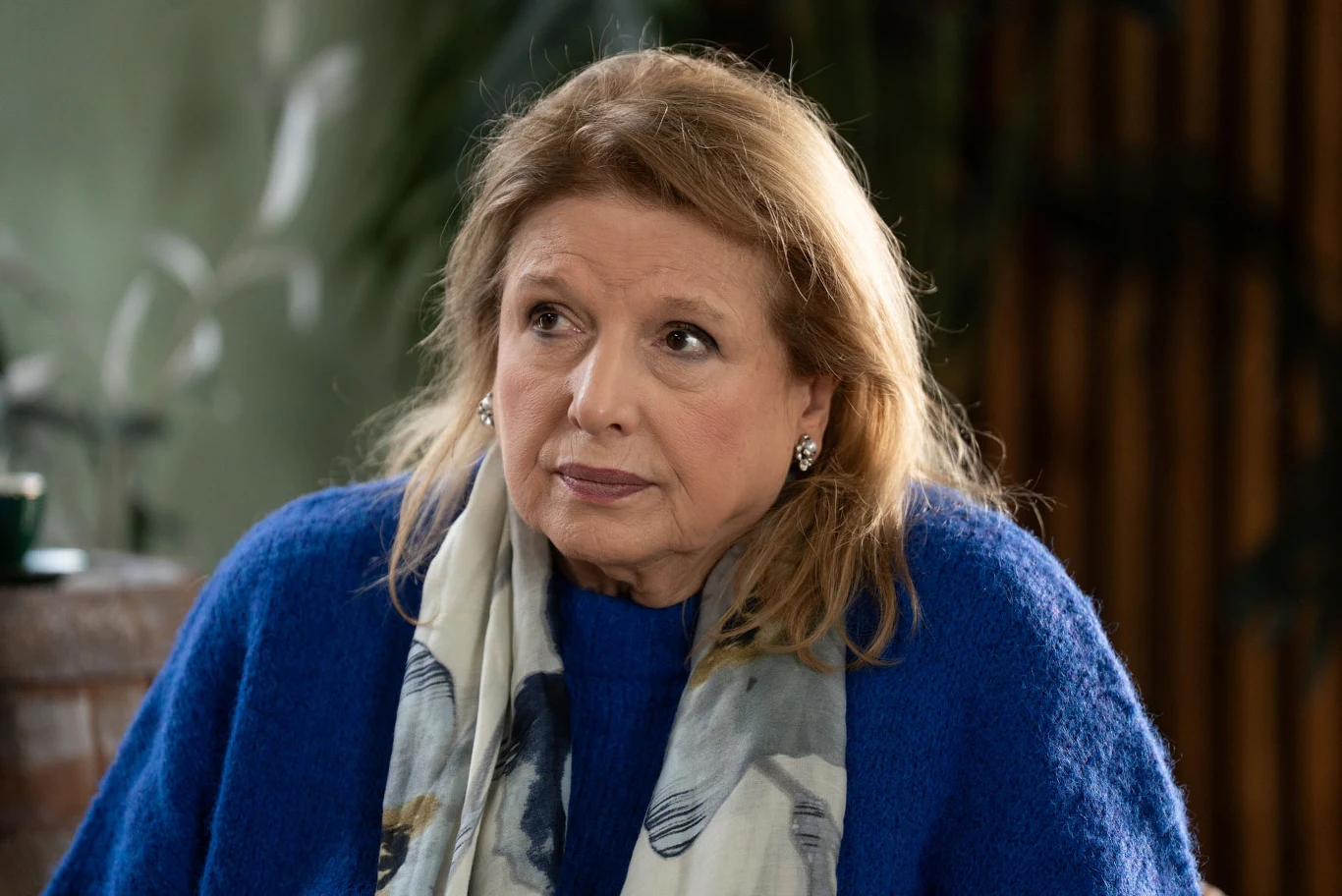 "Miałyśmy z Ewą doskonały kontakt, a teraz..." - powie Elżbieta Kobieta w średnim wieku z blond włosami, ubrana w niebieski sweter i szalik z delikatnym wzorem, siedzi w pomieszczeniu o ciepłym oświetleniu, z poważnym wyrazem twarzy.