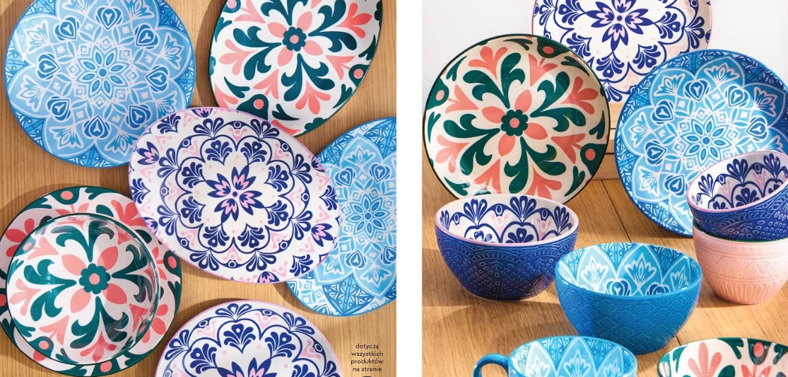 Nowa oferta Biedronki Kolorowe ceramiczne talerze i miseczki ozdobione ornamentowymi wzorami w odcieniach niebieskiego, różowego i zielonego, ułożone na drewnianej powierzchni.
