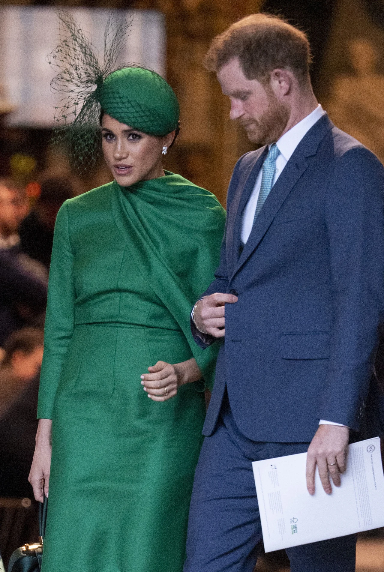 Ten rozdział w ich życiu może okazać się sporym wyzwaniem Elegancka kobieta w zielonej sukni i kapeluszu z ozdobnym woalem oraz mężczyzna w niebieskim garniturze stoją obok siebie w rozmowie, mężczyzna trzyma w ręku dokumenty.