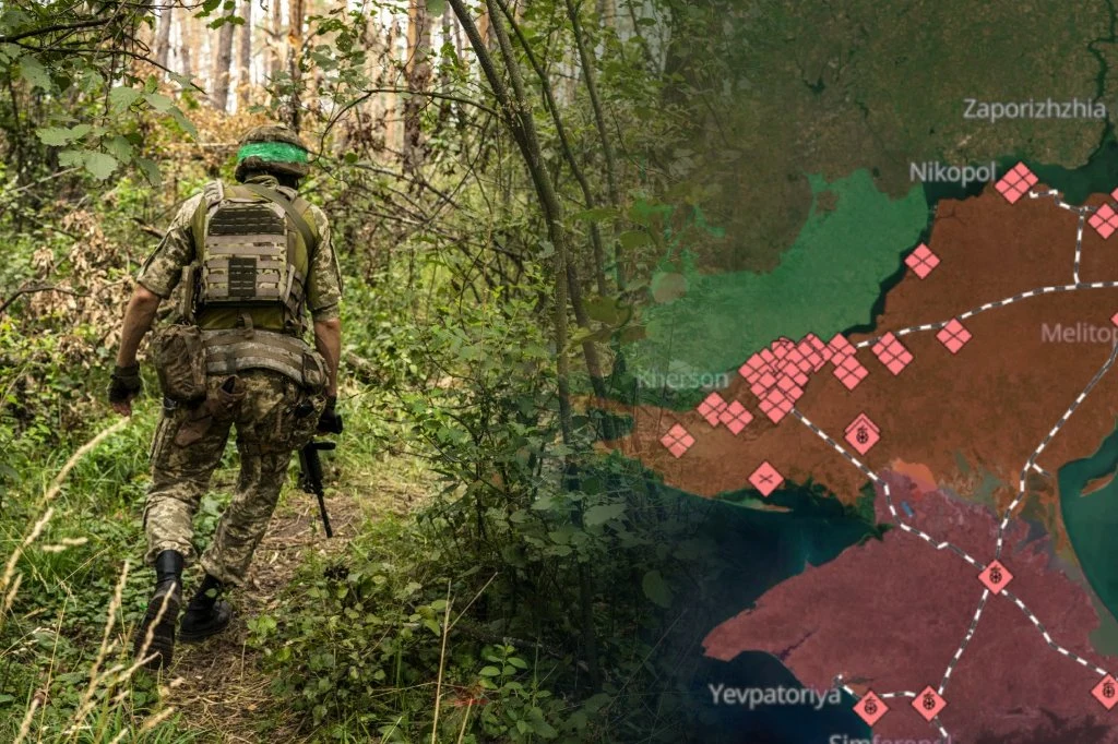 Wojna w Ukrainie. Rosjanie próbują zdobyć dawny zbiornik wodny w Kachowce Żołnierz w mundurze na leśnej ścieżce obok mapy z oznaczeniami działań wojennych na terenie Ukrainy.