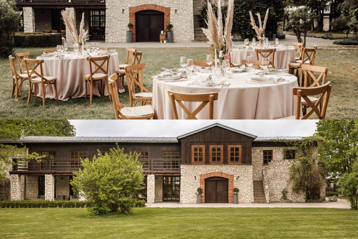 Okrągłe stoły z eleganckimi, jasnymi obrusami i ozdobami w postaci suchych traw ustawione na trawniku przed kamiennym budynkiem z drewnianymi elementami architektonicznymi.