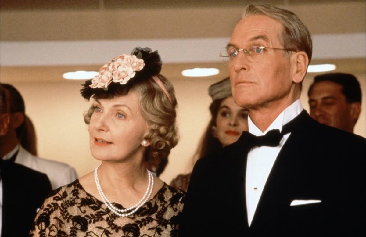 Z żoną, Joanne Woodward w filmie Mr. and Mrs. Bridge Starsza elegancka kobieta w czarnej sukni z koronką i perłowym naszyjnikiem, obok niej mężczyzna w smokingu z muchą, oboje patrzący w jednym kierunku z zainteresowaniem.