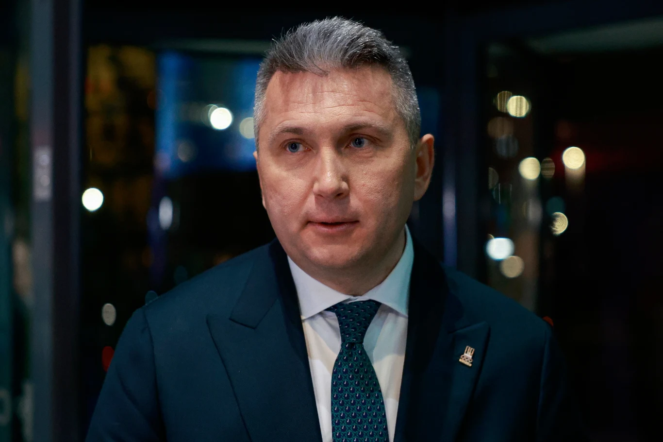 Radosław Piesiewicz Radosław Piesiewicz w garniturze i krawacie, stojący pod jasnym oświetleniem, patrzy lekko w bok.